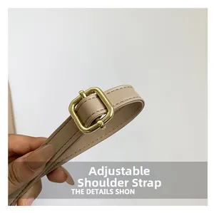 Detail of adjustable beige faux leather shoulder strap with a gold square buckle
