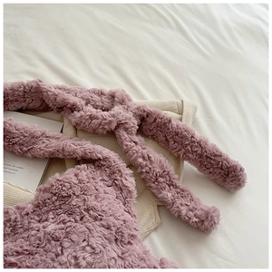 Macro detail of plush pink faux fur texture and matching shoulder strap on handbag