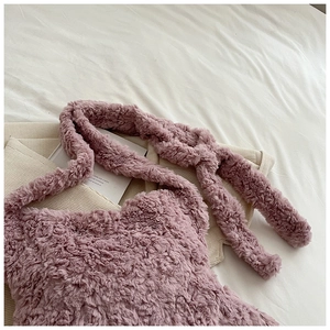 Close-up of soft plush texture and knotted strap on a dusty pink fuzzy shoulder bag