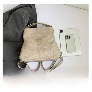 Detail showing beige pleated texture backpack with tablet for capacity demonstration