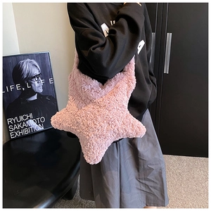 Detail view of the soft pink plush star-shaped handbag texture and premium material