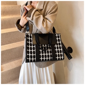 Detail of vintage black and white tweed tote bag with leather flap and wide strap