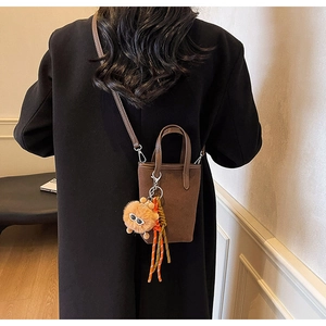 Détail du mini sac seau léopard vintage avec breloque petit monstre orange en peluche