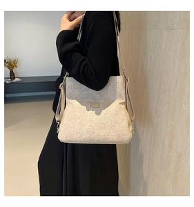 Detail of cream pleated texture backpack with metallic logo plate for a stylish look