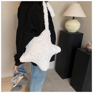 Detail view of white plush star-shaped crossbody bag with wide soft shoulder strap