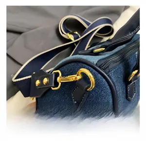 Dettaglio del gancio in metallo dorato e trama in denim sulla borsa a tracolla casual