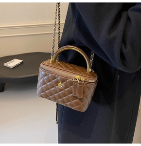 Detailansicht der braunen gesteppten Box-Tasche mit goldener Blumen-Schließe