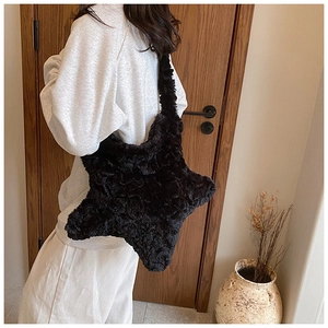 Detail of black faux fur star-shaped crossbody bag featuring soft plush texture