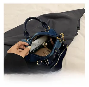 Vista interna della borsa Boston in denim blu che mostra la capacità con cellulare e trucchi