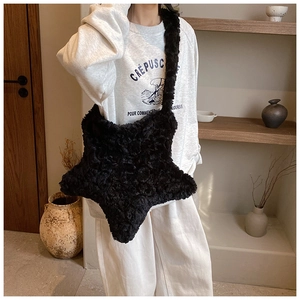 Detail of black plush star-shaped shoulder bag featuring soft faux fur texture and fuzzy strap