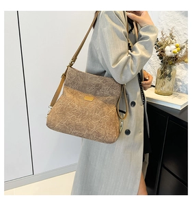 Brown handbag with marble texture and gold hardware shown on a model in a grey blazer