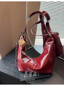 Deep red glossy leather hobo shoulder bag with a cute bear charm and striped strap