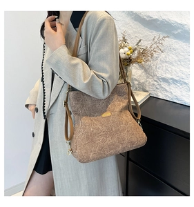 Detail of dark brown crinkled texture tote with gold hooks and thin leather straps