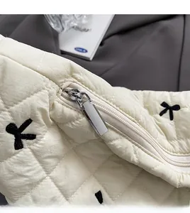 Detail of silver zipper and quilted fabric with black butterfly embroidery