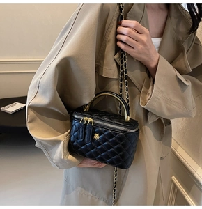 Detailansicht der schwarzen gesteppten Mini-Tasche mit goldener Kamelie und Kette