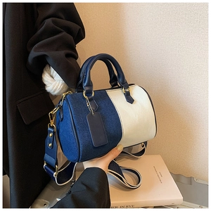 Dettaglio della borsa Boston con trama denim, pelle crema e finiture metalliche dorate