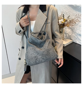 Close-up of grey textured hobo bag with marble-effect material and gold metal hardware