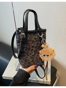 Mini sac seau vintage imprimé léopard avec pendentif en peluche et lanières en cuir noir