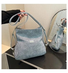 Detailed view of the blue marble texture and metal logo on this chic crossbody bag
