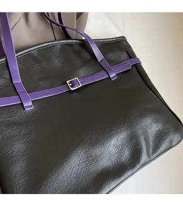 Detail of soft black lychee texture leather with purple handle and silver buckle