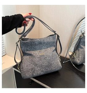 Detail showing marble texture grey handbag with golden hardware and adjustable strap