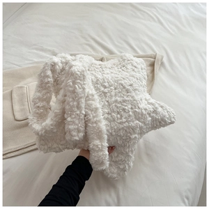 Detail of white star-shaped plush shoulder bag featuring soft faux fur fuzzy texture
