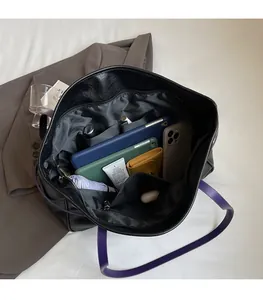 Top view of large black tote bag showing spacious compartments and purple straps