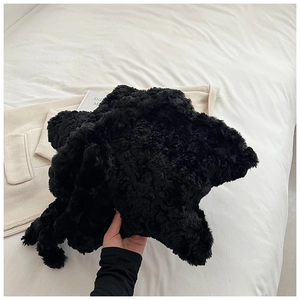 Close-up of soft black plush faux fur shoulder bag texture with fluffy star design detail