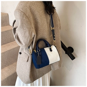 Borsa Boston in tela bicolore blu e beige indossata a spalla da una modella