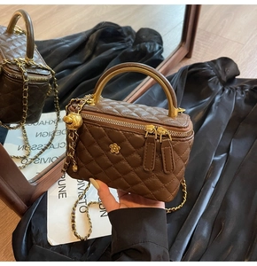 Detailansicht der braunen gesteppten Kosmetiktasche mit Goldkette und Metallgriff