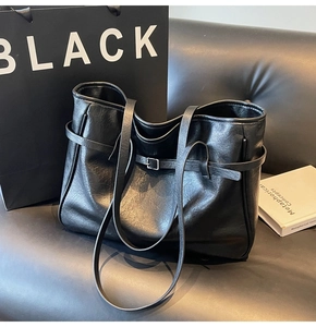 Macro detail of high-quality black PU leather tote bag with decorative strap buckle