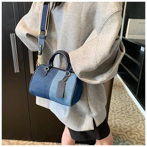 Dettaglio borsa Boston in denim con manici in pelle e tracolla in tessuto regolabile