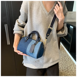 Dettaglio della borsa Boston patchwork in denim blu con manici in pelle e tracolla
