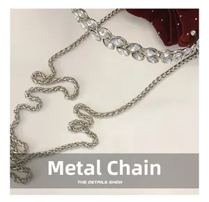 Close-up of silver hardware chain with marquise crystals and red velvet fabric