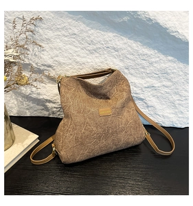 Detailed view of the brown textured fabric shoulder bag with an adjustable strap