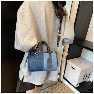 Dettaglio borsa Boston in denim patchwork con finiture dorate e tracolla ampia