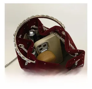 Internal capacity of the velvet bucket bag showing space for phone and makeup
