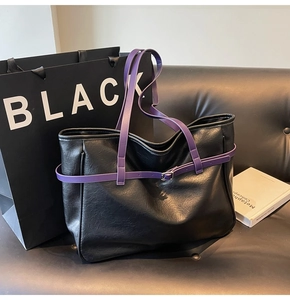 Close-up of black lychee texture tote bag featuring contrasting purple straps and buckle