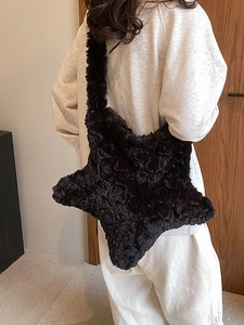 Star-shaped black plush shoulder bag featuring soft faux fur and a wide strap design