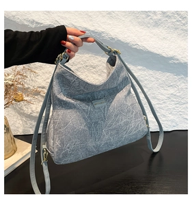 Detail of grey marble texture crossbody bag with gold hardware and logo plate
