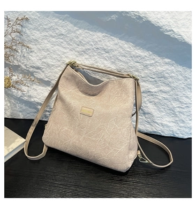 Close-up of beige cracked leather texture and gold metal hardware on the tote bag