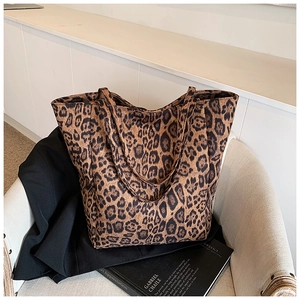 Gros plan du sac cabas léopard posé sur un fauteuil dans un intérieur de style moderne