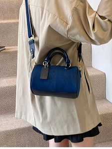 Borsa Boston classica in denim e pelle con tracolla larga indossata da una modella