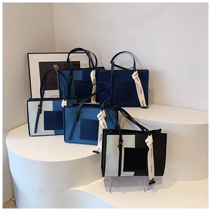 Detailed close-up of colorful denim tote bags with ribbons on minimalist display