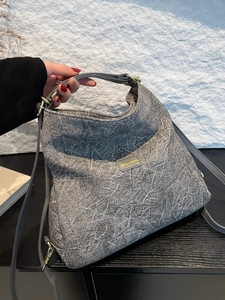 Grey textured handbag with abstract white lines, leather handles and gold hardware