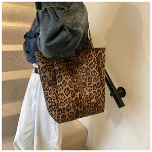 Détail d'un grand sac cabas à motif léopard porté par un mannequin en tenue décontractée