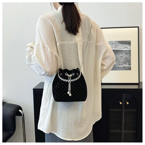 Detail of black velvet bucket bag with silver rhinestones and pearl drawstring tassels