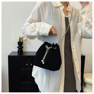 Detail of black velvet drawstring bucket bag with pearls and silver chain strap