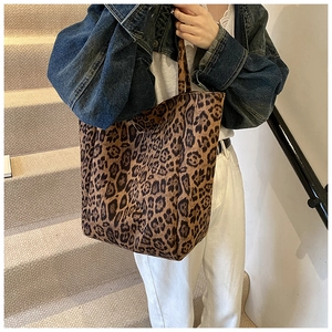 Mannequin portant le grand sac cabas en toile à imprimé léopard dans un escalier
