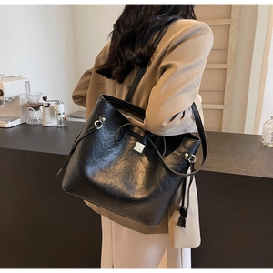 Detailansicht der schwarzen Leder-Tote-Bag mit Kordelzug und metallischer Schnalle